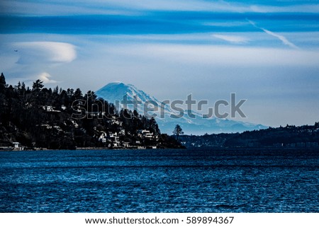 Distant Rainier II: Mount Rainier peeks out above Magnolia and the Puget Sound. Royalty-Free Stock Photo #589894367