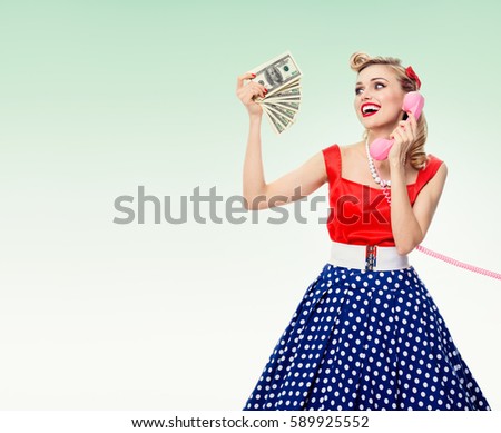 Woman with money, talking on phone, dressed in pin-up style, on green background. Caucasian model in retro fashion and vintage concept shoot. Copyspace area for advertising slogan or text message.