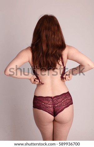Young woman with curves in her maroon underwear.