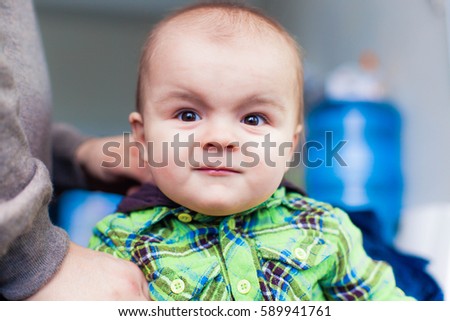 Little baby toddler making faces posing at the background of water cooler, closeup portrait, smiling, nice, moving, pathetic