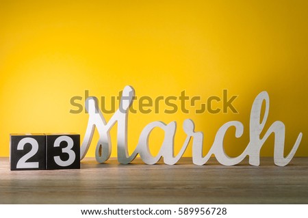 March 23rd. Day 23 of month, daily wooden calendar on table with yellow background. Spring time, empty space for text Royalty-Free Stock Photo #589956728
