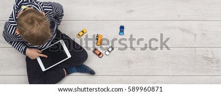 kid playing with his tablet pc Royalty-Free Stock Photo #589960871