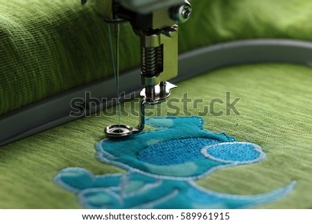 Embroidery with embroidery machine - comic dog application - satin stitch border with visible frame- background and foreground blanked out blurry 