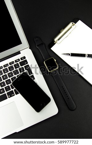 laptop phone clock on a black background