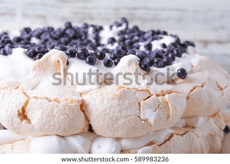 meringue cake with cream decorated with blueberries