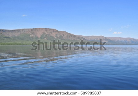 Mountain lake in the morning. Summer wild landscape water lake on the Putorana Plateau.