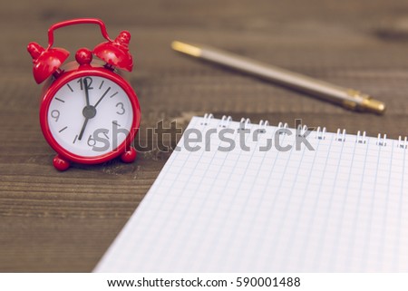alarm clock, notepad and pen
