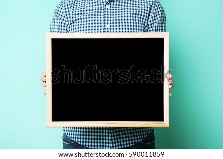Male hands holding wooden frame on green background