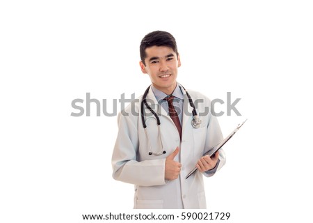 young beautiful doctor in blue uniform with stethoscope on his neck make notes and smiles isolated on white background