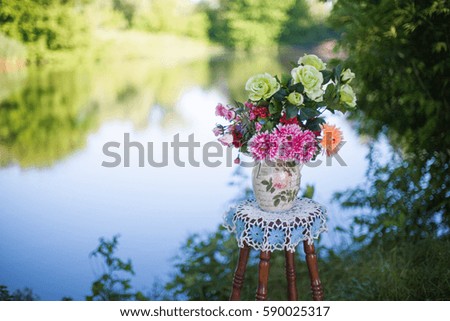 plastic bouquet on the chair or stool at a riverside, sunny morning