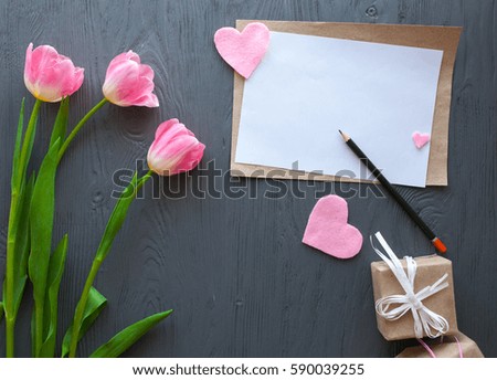 Mother's Day, woman's day. pink  tulips ,presents and letter on wooden background