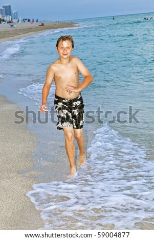 young boy is jogging at the beautiful beach