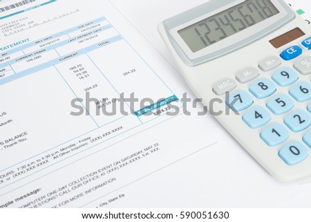 Close up shot of unpaid utility bill and calculator over it