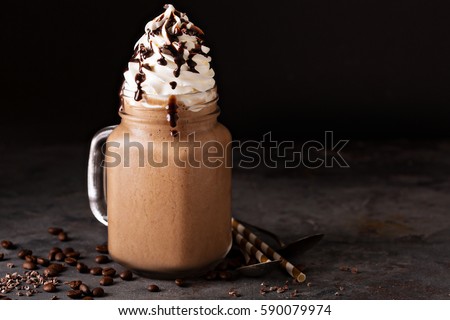 Chocolate frappe coffee with whipped cream and syrup on dark background Royalty-Free Stock Photo #590079974
