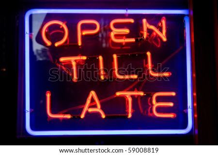 Blue and red neon sign of the words 'Open till late' inside a square of neon, on a black background.