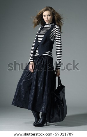 Fashion girl with bag posing in the studio