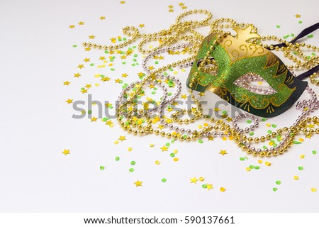Carnival green and gold masks and beads on a white background. Space for text.