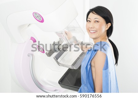 Portrait Of Happy Mature Woman Undergoing Mammogram X-ray Test