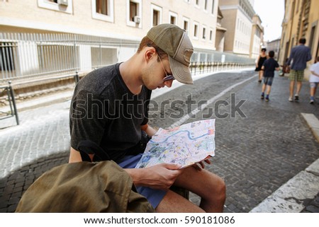 Tourist considering map of city in Rome