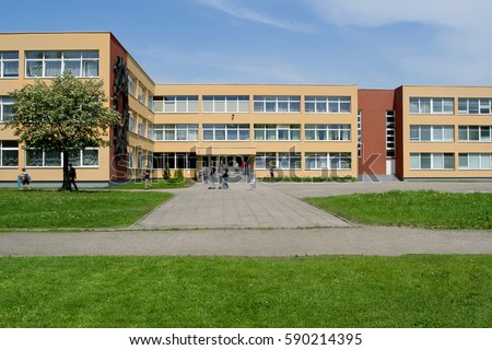 Public school building. Exterior view of school building with playground. Royalty-Free Stock Photo #590214395