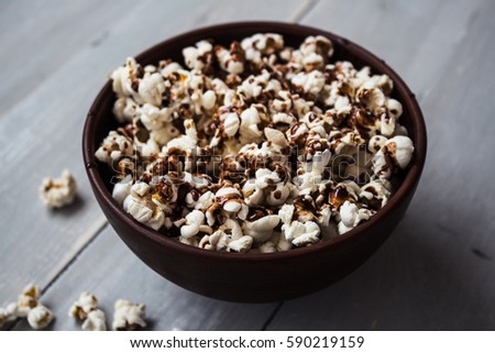 a bowl with chocolate popcorn on wood Royalty-Free Stock Photo #590219159