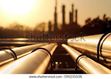 golden sunset in crude oil refinery with pipeline system Royalty-Free Stock Photo #590235038