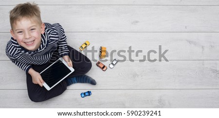 Kid playing with his ipad Royalty-Free Stock Photo #590239241