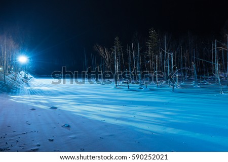 Blue pond illumination light up in winter night at Biei, Hokkaido, Japan.  During the winter when the pond is frozen, it is lighting up at night