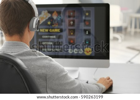 Teenager playing computer game at home