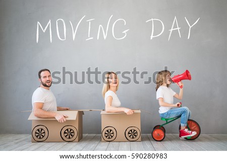 Happy family playing into new home. Father, mother and child having fun together. Moving house day and express delivery concept