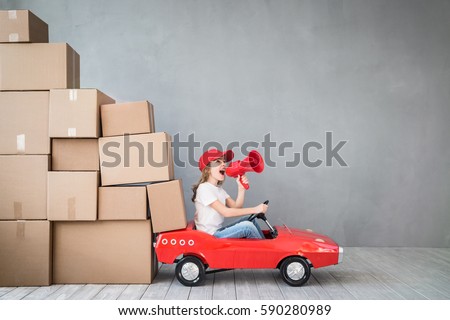 Happy child playing into new home. Kid having fun indoor. Moving house day and express delivery concept