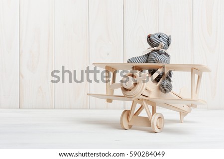 Cute teddy bear on wooden background with wooden baby toys Royalty-Free Stock Photo #590284049