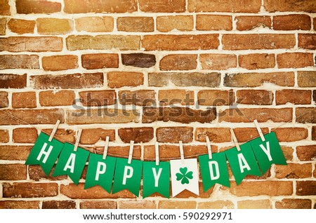 HAPPY ST. PATRICK'S DAY banner lettering on red, old orange brick wall background. Irish national colors St. Patrick's Day greeting postcard template. Space for cope, text.
