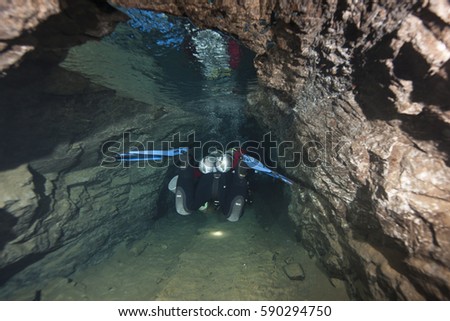 Technical Scuba Diver entering the cave system under the city of Budapest, Hungary Royalty-Free Stock Photo #590294750