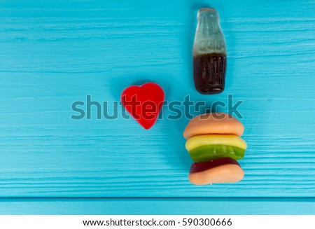 Jelly candies represent in the form of a burger and drink that is love on wooden turquoise table