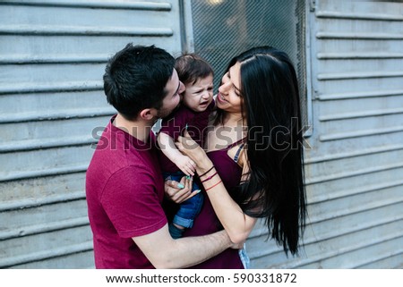 young beautiful family with child posing on the building background