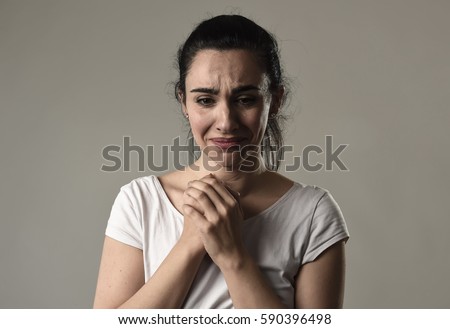 beautiful face of sad woman crying desperate and depressed with tears on her eyes suffering pain and depression isolated on grey background in sadness facial expression and emotion concept Royalty-Free Stock Photo #590396498