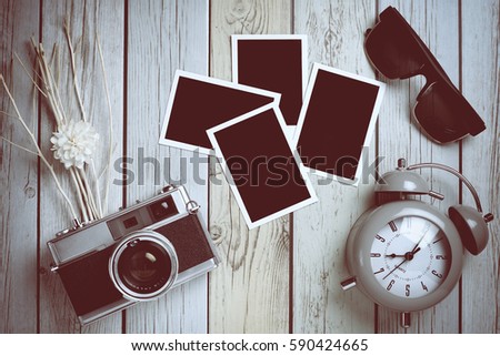 Retro camera with empty old instant paper photo album and teddy bear on wood background, top view (vintage style)