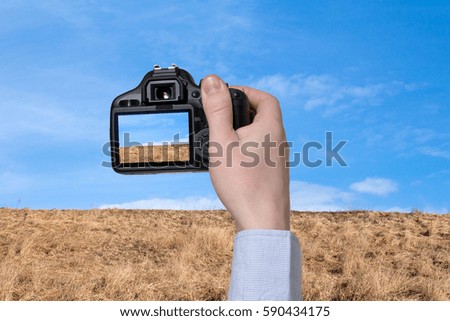 The digital camera in a hand. Landscape picture