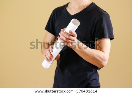 Guy holds in his hands twisted up in paper. Opens the package of paper. Shows a blank sheet rolled into a tube. Man showing blank white flyer brochure booklet. Man show clear offset paper.