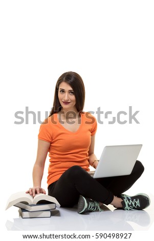 Young woman working with laptop and book.