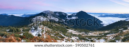 From the valley covered with snow the fantastic panorama is opened to high mountains, lake and fog in autumn morning. 
