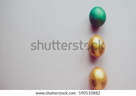 Beautiful colorful green and golden easter eggs with confectionery sprinkling and brush on pink background