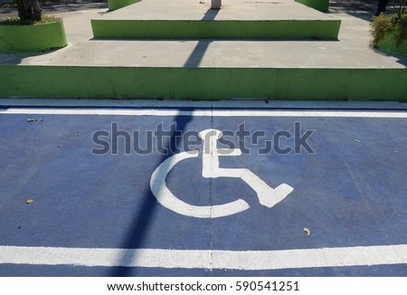 Close up of empty handicapped reserved parking space with wheelchair symbol on asphalt on street