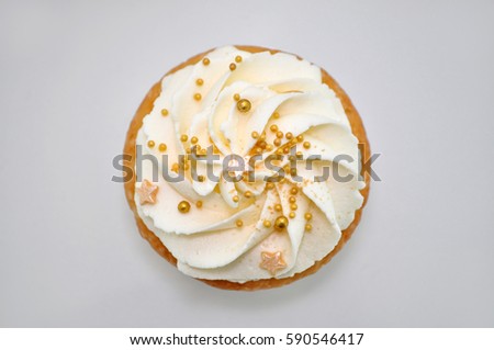 Cupcake with cream and gold confectionery sprinkling. Top view. Picture for a menu or a confectionery catalog.