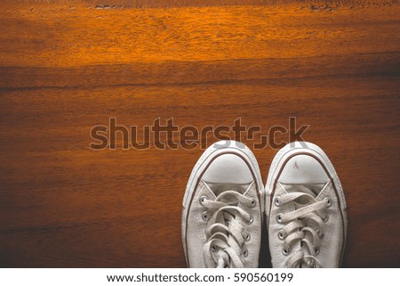 Top view Old vintage sneakers on hardwood floors,brown with copy space