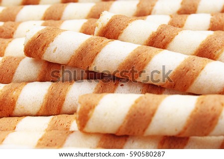 Ice cream wafer curls sticks as background. Wafer biscuit swirled stick texture. Wafers pattern. Wafer curl background.