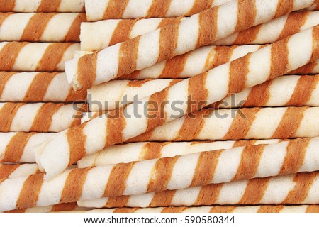 Ice cream wafer curls sticks as background. Wafer biscuit swirled stick texture. Wafers pattern. Wafer curl background.