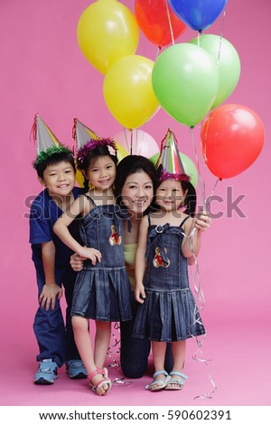 Mother and three children, posing with balloons