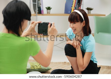 Young woman taking a picture of another young woman